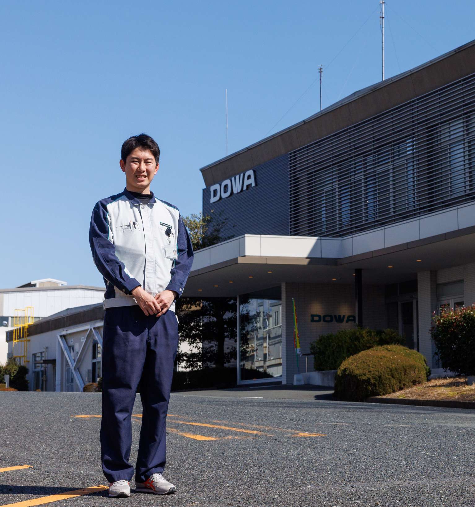 社屋を背に立つ笠谷さん