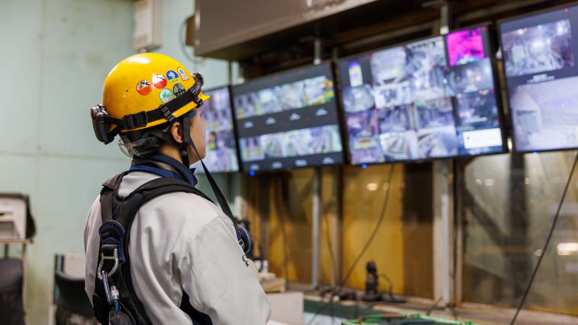 スチールプランテック工場内でモニターを見る石澤さん